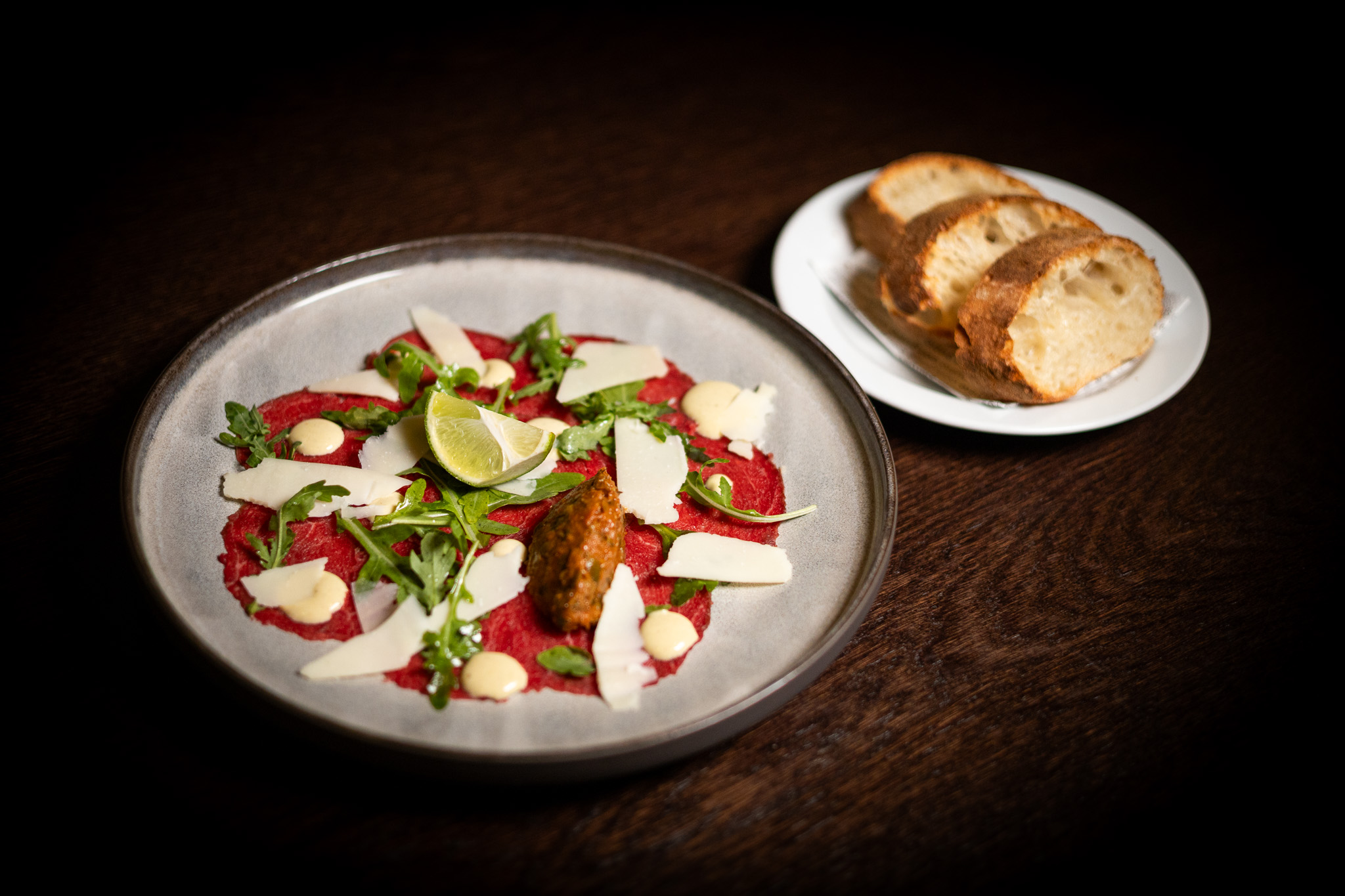 Carpaccio di manzo con pomodori secchi, maionese ai capperi, parmigiano, rucola, ciabatta