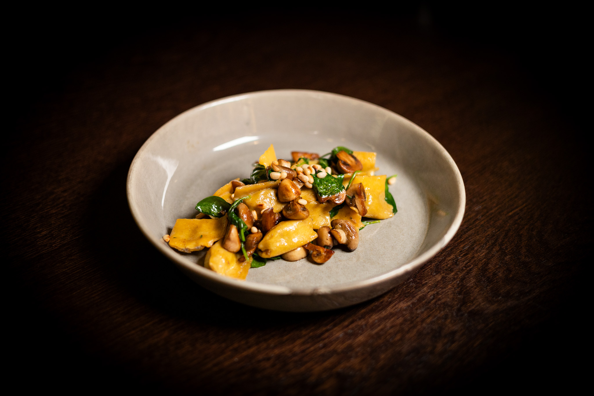 Tortellini ripieni di funghi champignon e ricotta, baby spinaci, funghi saltati, pinoli e parmigiano