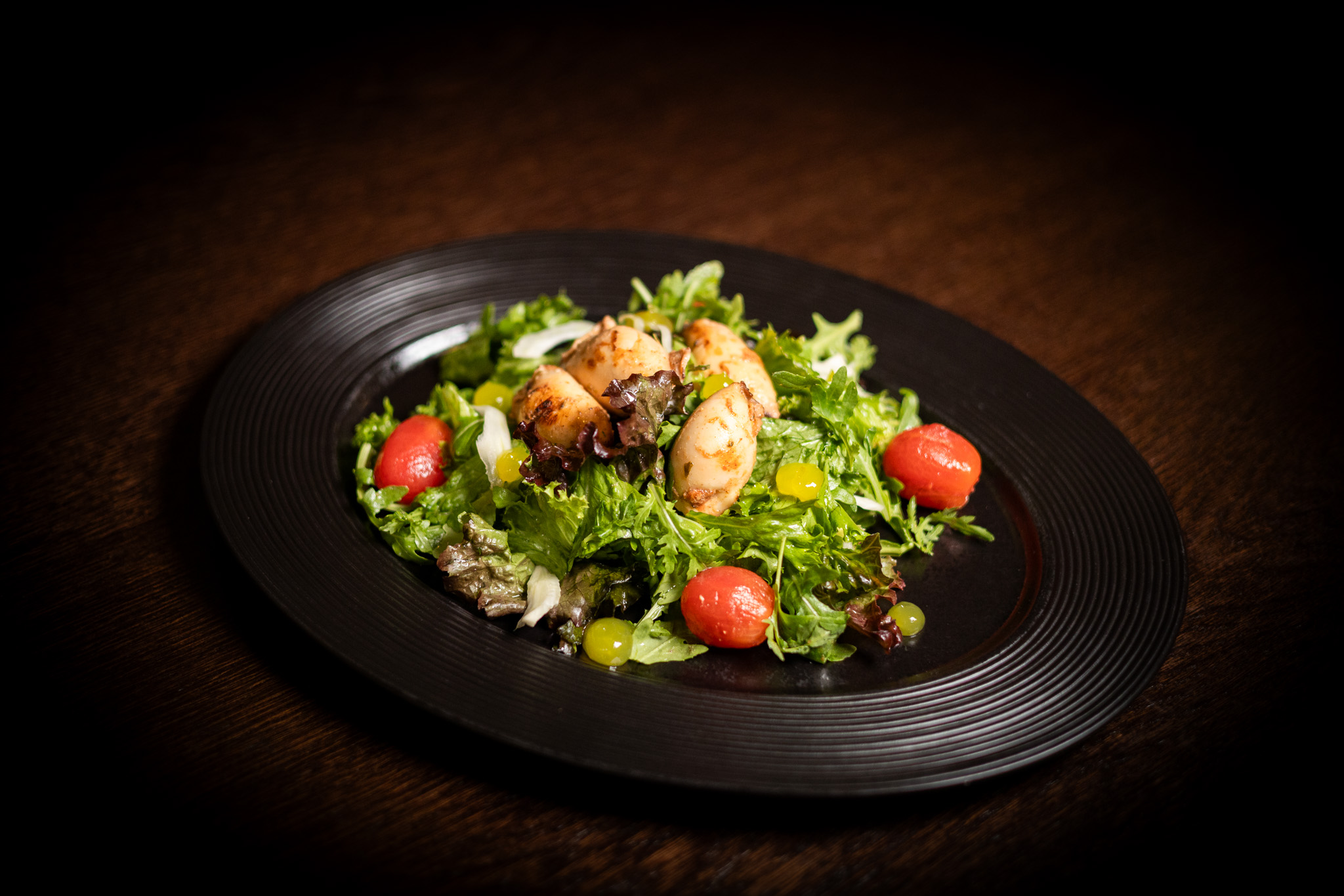 Insalata con finocchio marinato e pomodori, calamari grigliati