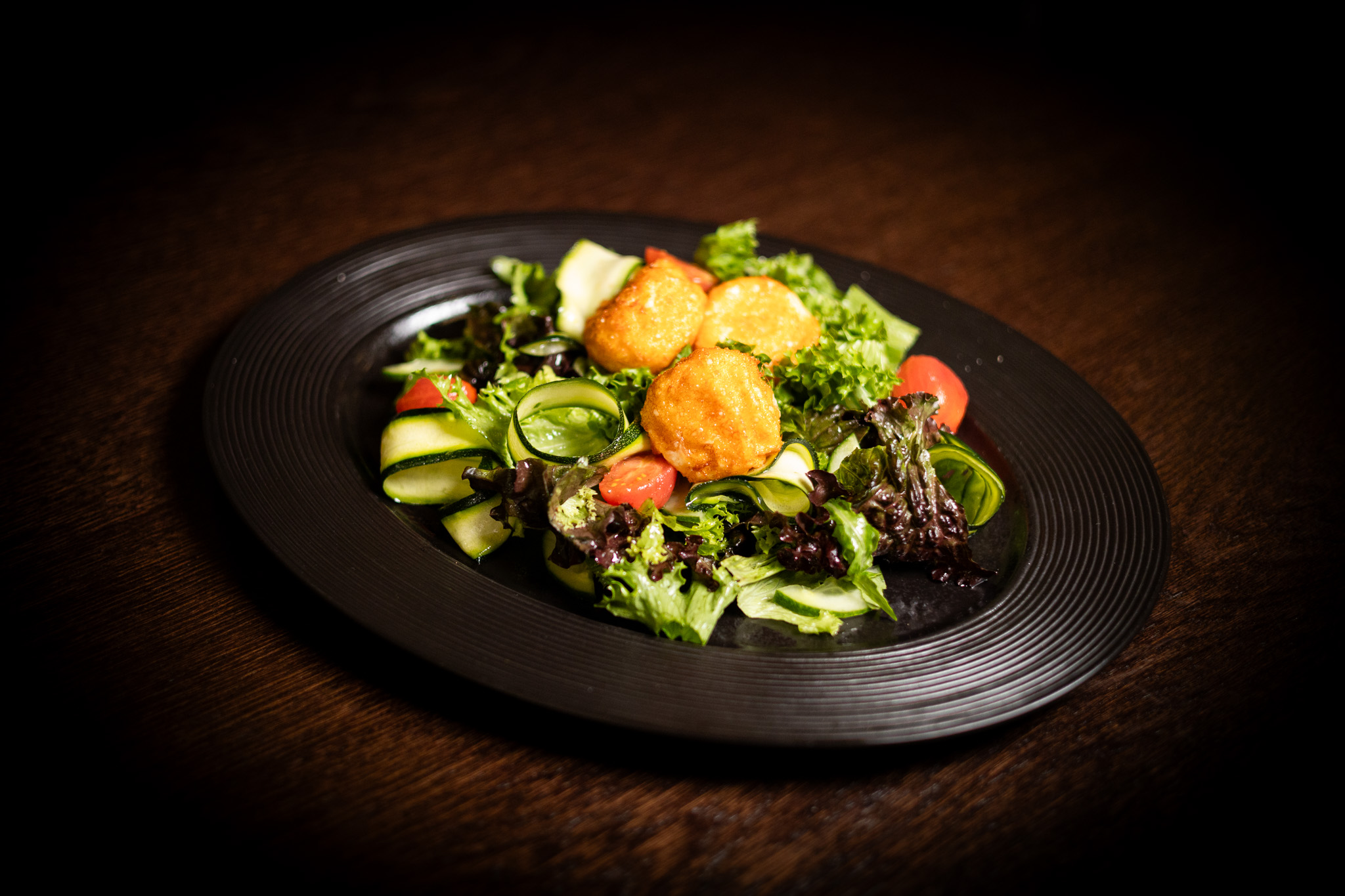 Insalata con zucchine marinate, cetrioli, pomodori e crocchette fritte di mozzarella