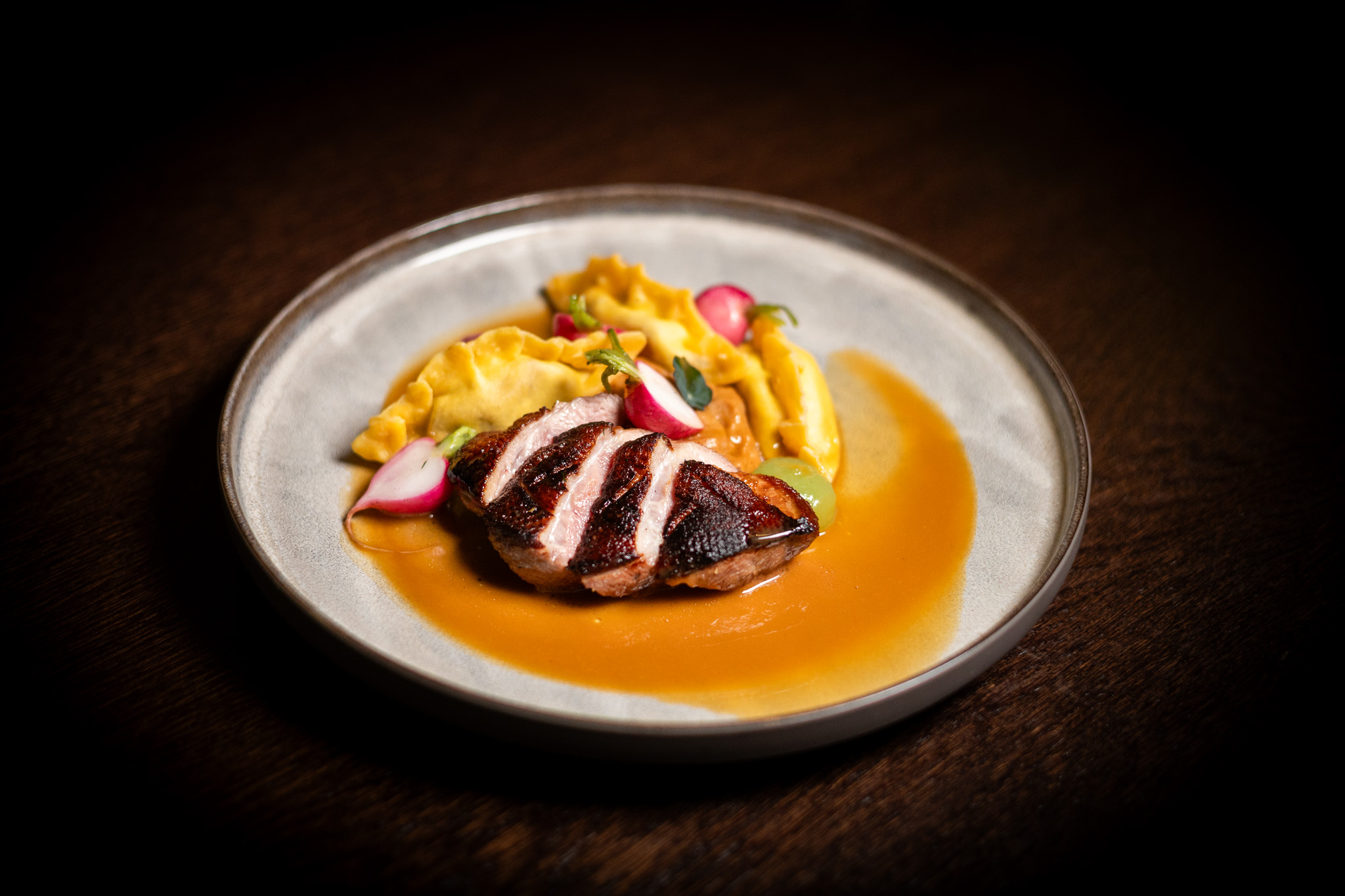 Petto d’anatra alla griglia, purè di brioche, ravioli ripieni di marmellata di cipolle e pancetta
