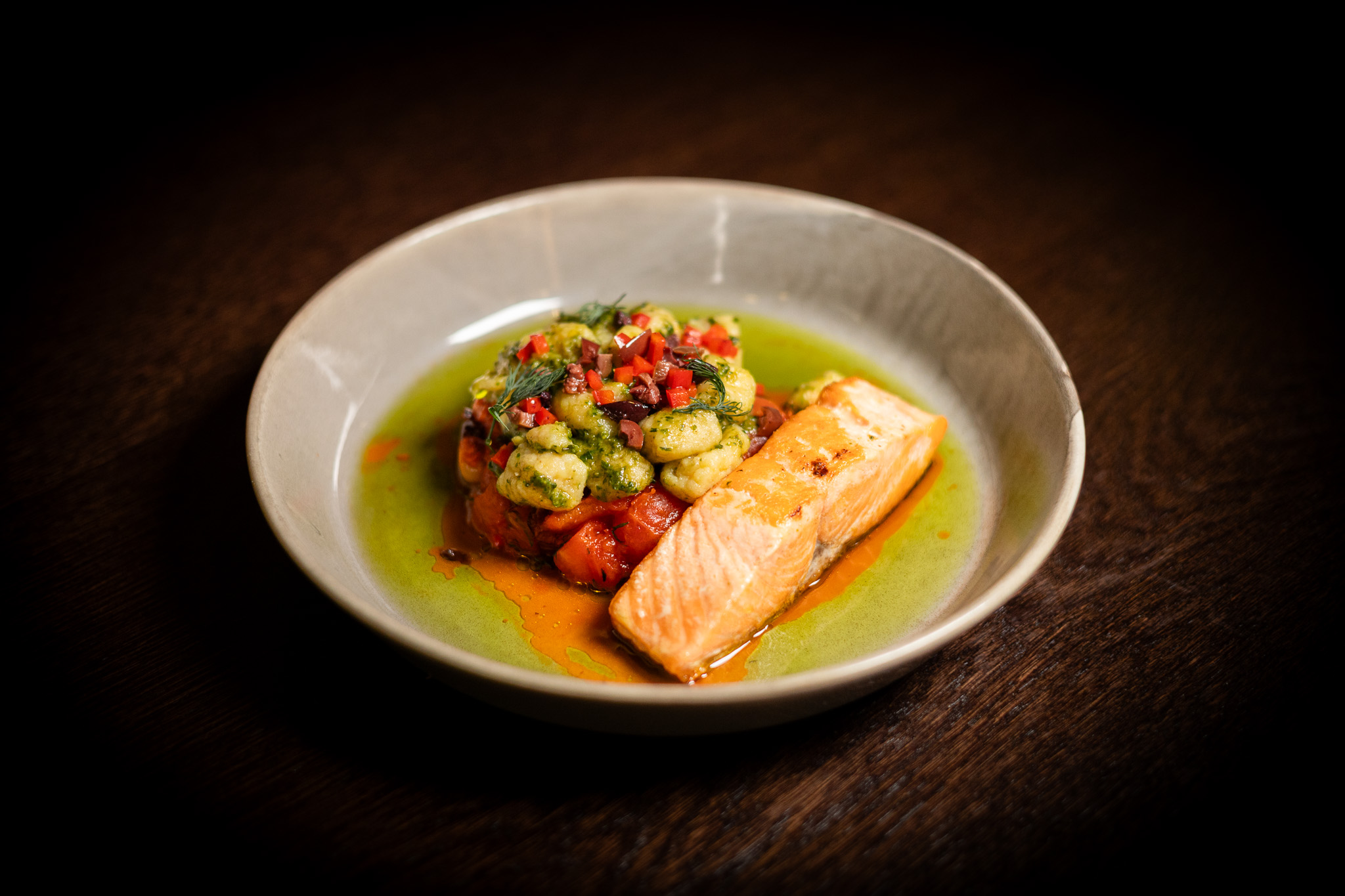 Filetto di salmone alla griglia, gnocchi allo zafferano con salsa di pomodori, olive, peperoni e aneto